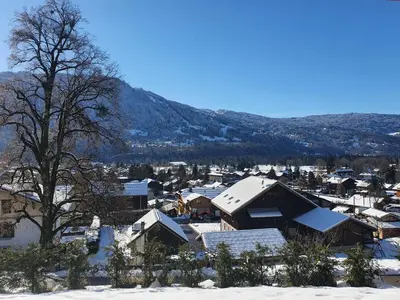 a town covered in snow with a mountain in the background at Plein Soleil 3 bedroom apartment with stunning mountain views in Samoëns