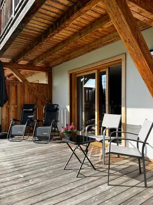 a group of chairs and a table on a deck at Plein Soleil 3 bedroom apartment with stunning mountain views in Samoëns