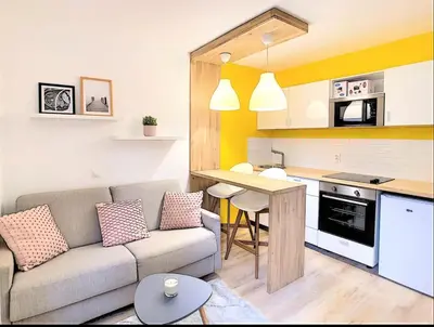 a living room with a couch and a kitchen at Centre Saint-Gervais studio Jaune moderne proche télécabine 2 pers in Saint-Gervais-les-Bains