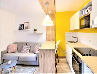 a living room with a couch and a table in a kitchen at Centre Saint-Gervais studio Jaune moderne proche télécabine 2 pers in Saint-Gervais-les-Bains