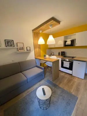a living room with a couch and a table at Centre Saint-Gervais studio Jaune moderne proche télécabine 2 pers in Saint-Gervais-les-Bains