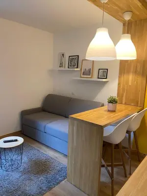 a living room with a blue couch and a table at Centre Saint-Gervais studio Jaune moderne proche télécabine 2 pers in Saint-Gervais-les-Bains