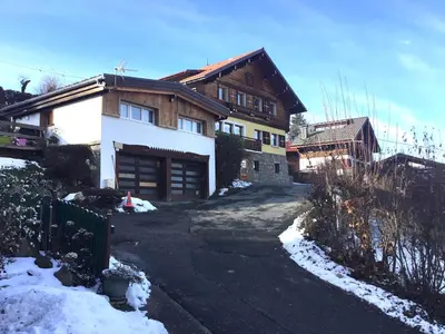 a house in the snow with a driveway at CHAMBRE INDÉPENDANTE avec SALLE DE BAIN INDÉPENDANTE au RDC d un chalet à 25 kms Chamonix in Saint-Gervais-les-Bains
