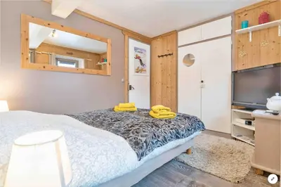 a bedroom with a bed and a flat screen tv at CHAMBRE INDÉPENDANTE avec SALLE DE BAIN INDÉPENDANTE au RDC d un chalet à 25 kms Chamonix in Saint-Gervais-les-Bains