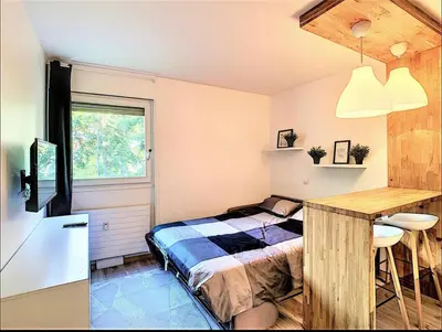 a bedroom with a bed and a desk and a table at Centre Saint-Gervais Studio Vert moderne 2 pers proche télécabine in Saint-Gervais-les-Bains