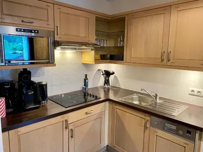 a kitchen with wooden cabinets and a sink at Le REFUGE DES PORTES DU MONT BLANC in Vallorcine
