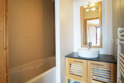 a bathroom with a sink and a tub and a mirror at Le REFUGE DES PORTES DU MONT BLANC in Vallorcine