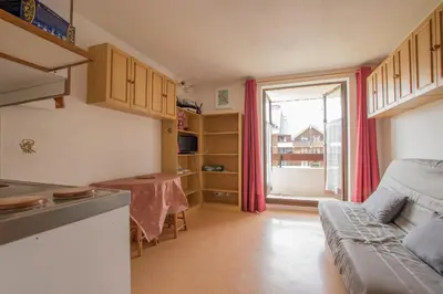a kitchen with a couch and a table in a room at Studio Ella au cœur du village in Samoëns