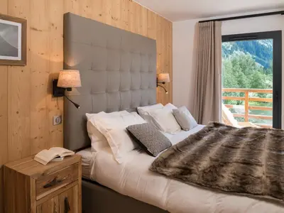 a bedroom with a large bed and a window at La Cordee 623-Luxury apartment with mountain view and SPA in Chamonix-Mont-Blanc