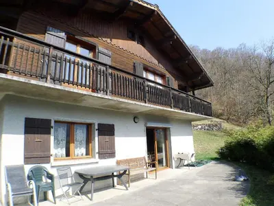 a building with a balcony and a table and chairs at Chalet familial calme proche centre, 8 pers, WiFi, garage - FR-1-629-103 in Samoëns