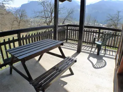 a wooden bench sitting on a balcony with a chair at Chalet familial calme proche centre, 8 pers, WiFi, garage - FR-1-629-103 in Samoëns