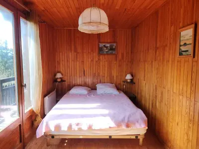 a bedroom with a bed in a wooden wall at Chalet familial calme proche centre, 8 pers, WiFi, garage - FR-1-629-103 in Samoëns