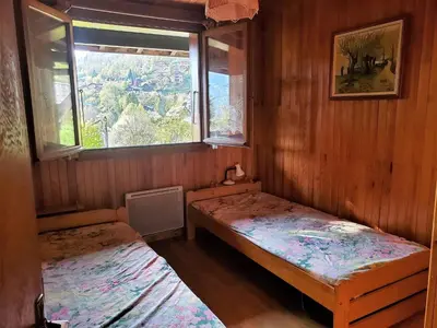 a small room with two beds and a window at Chalet familial calme proche centre, 8 pers, WiFi, garage - FR-1-629-103 in Samoëns