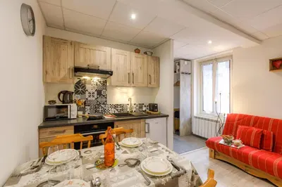 a kitchen and living room with a table and a red couch at La Maisonnée de Julie - Happy Rentals in Chamonix-Mont-Blanc