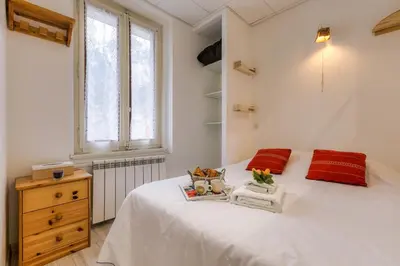 a bedroom with a large white bed with red pillows at La Maisonnée de Julie - Happy Rentals in Chamonix-Mont-Blanc