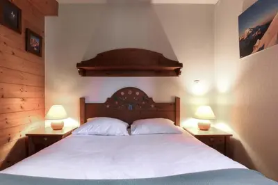 a bedroom with a large white bed with two lamps at Prarion ski in ski out and swimming pool ! in Les Houches