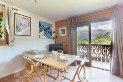 a dining room with a table and a balcony at Prarion ski in ski out and swimming pool ! in Les Houches