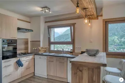 a kitchen with wooden cabinets and a large window at Chalet Mirador appartement vue panoramique SITUÉ À 25 kms de CHAMONIX in Saint-Gervais-les-Bains