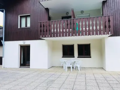 a patio with a table and chairs in front of a building at Confortable 3 pièces avec terrasse, idéal pour 6 personnes - FR-1-629-100 in Samoëns