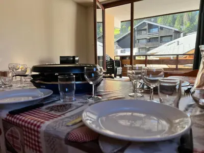 a table with plates and wine glasses on it at Appartement lumineux au pied des pistes avec accès direct Grand Massif - FR-1-624-100 in Morillon