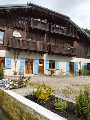 a building with wooden balconies and flowers in front of it at Chalet La Ferme d'Henriette, à Samoëns in Samoëns