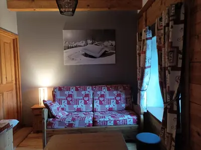 a living room with a couch and a picture on the wall at Chalet La Ferme d'Henriette, à Samoëns in Samoëns