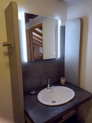 a bathroom sink with a mirror on a counter at Chalet La Ferme d'Henriette, à Samoëns in Samoëns