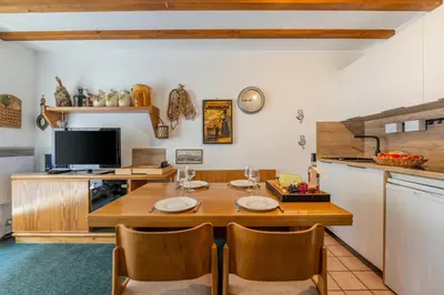 a dining room with a table and a tv at Appartement Des Lacs - Happy Rentals in Chamonix-Mont-Blanc