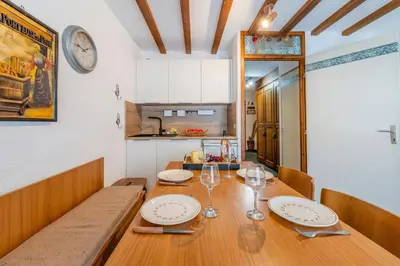 a dining room with a wooden table and a kitchen at Appartement Des Lacs - Happy Rentals in Chamonix-Mont-Blanc