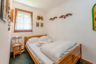 a bedroom with a bed with white sheets and a window at Appartement Des Lacs - Happy Rentals in Chamonix-Mont-Blanc