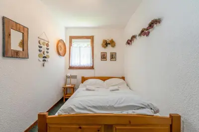 a bedroom with a bed with white sheets and a window at Appartement Des Lacs - Happy Rentals in Chamonix-Mont-Blanc