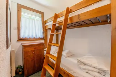 a bedroom with two bunk beds and a ladder at Appartement Des Lacs - Happy Rentals in Chamonix-Mont-Blanc