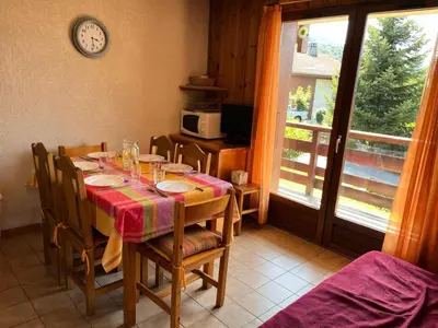 a dining room with a table with chairs and a clock at Résidence Coupe De Cristal - Coupe de Cristal A6 MAE-6544 in Saint-Gervais-les-Bains