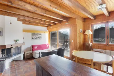 a kitchen and living room with a table and chairs at Chalet Charousse in Les Houches