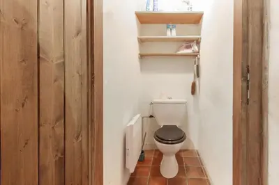 a small bathroom with a toilet and a wooden door at Chalet Charousse in Les Houches