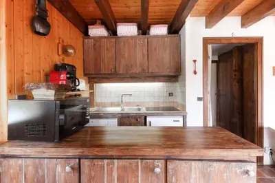 a kitchen with wooden cabinets and a microwave at Chalet Charousse in Les Houches