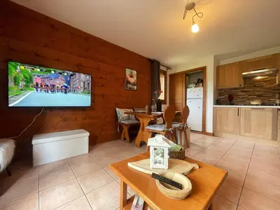 a living room with a television on a wall at Appartement calme à Samoëns avec piscine et WiFi - FR-1-624-101 in Samoëns