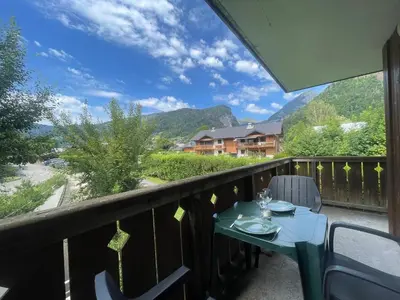a table and chairs on a balcony with a view at Appartement calme à Samoëns avec piscine et WiFi - FR-1-624-101 in Samoëns