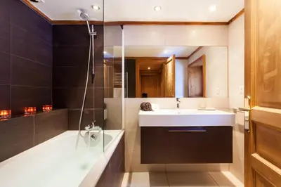 a bathroom with a tub and a sink and a bath tubermottermott at Chalet Tissières in Chamonix-Mont-Blanc