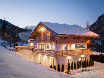 a house in the snow with lights on at Chalet Rubicon in Les Houches