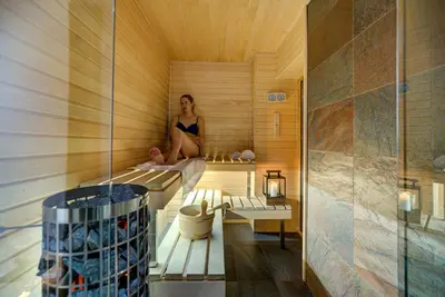 a woman sitting in a sauna with a person in it at Chalet Rubicon in Les Houches