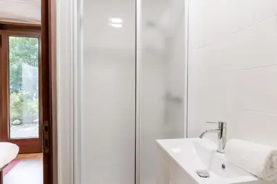 a white bathroom with a sink and a shower at Clos de l'Ours - 2 chambres - Jardin privé in Chamonix-Mont-Blanc