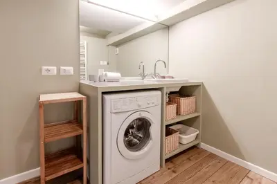 a laundry room with a washing machine and a sink at Clos de l'Ours - 2 chambres - Jardin privé in Chamonix-Mont-Blanc