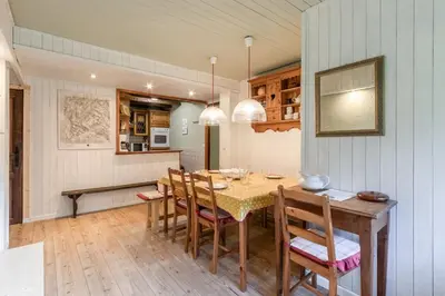 a kitchen and dining room with a table and chairs at Clos de l'Ours - 2 chambres - Jardin privé in Chamonix-Mont-Blanc