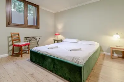 a bed in a room with a chair and a table at Clos de l'Ours - 2 chambres - Jardin privé in Chamonix-Mont-Blanc