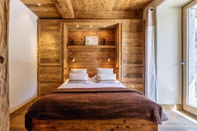 a bedroom with a large bed with wooden walls at Appartement Arsene No 6 - Happy Rentals in Le Tour