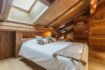 a large bed in a room with wooden walls at Appartement Arsene No 6 - Happy Rentals in Le Tour
