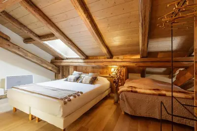 two beds in a room with wooden ceilings at Appartement Arsene No 6 - Happy Rentals in Le Tour