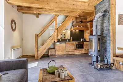 a large kitchen with wooden ceilings and a living room at Appartement Arsene No 6 - Happy Rentals in Le Tour