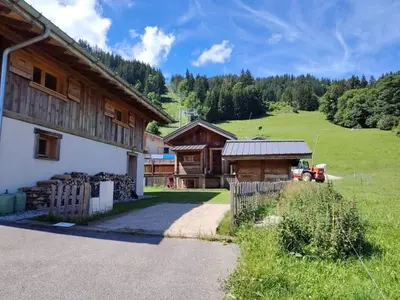 a barn with a tractor parked next to a building at Vielyterra - Chalet haut de gamme - Domaine du mont blanc in Saint-Gervais-les-Bains